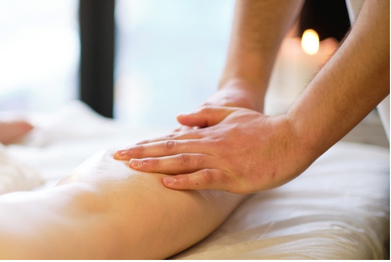 Massage therapist massaging a patient's leg
