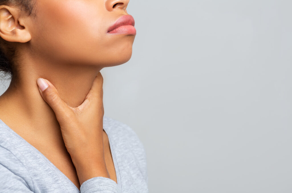 young woman performing a lymph node check in her neck.